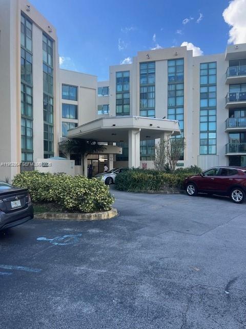 2055 Southwest 122nd Avenue, Unit 519 Miami, FL 33175 - Photo 1 of 13 a front view of a building with garden and parking