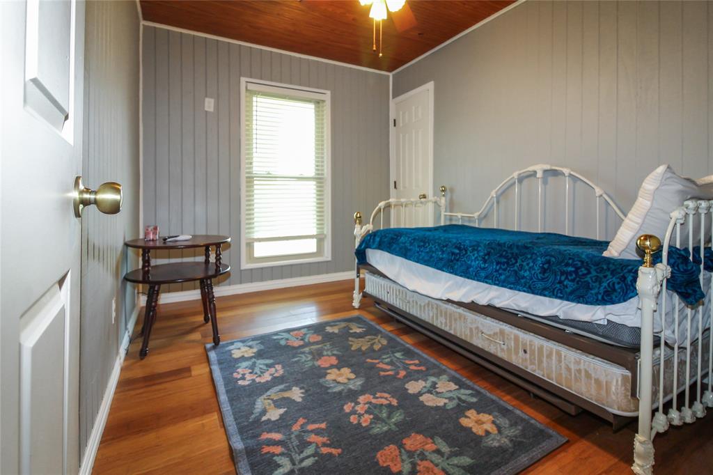 1001 Sandy Ridge Road Scurry, TX 75158 - Photo 21 of 35 Room featuring wood-finish flooring, vertical paneling on walls, and a natural wood-plank ceiling