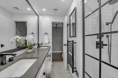 a bathroom with a double vanity sink mirror and shower
