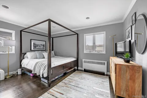 a bedroom with a bed and a flat tv screen on the dresser