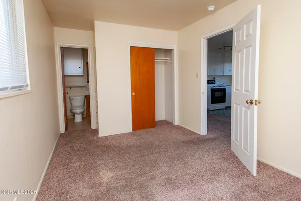 an empty room with closet and a bathroom