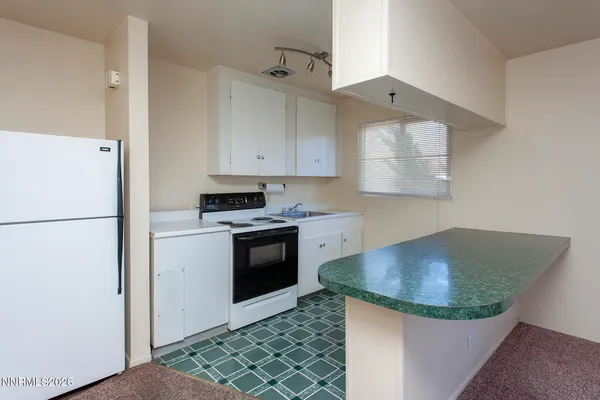 a kitchen with granite countertop a sink stove and refrigerator