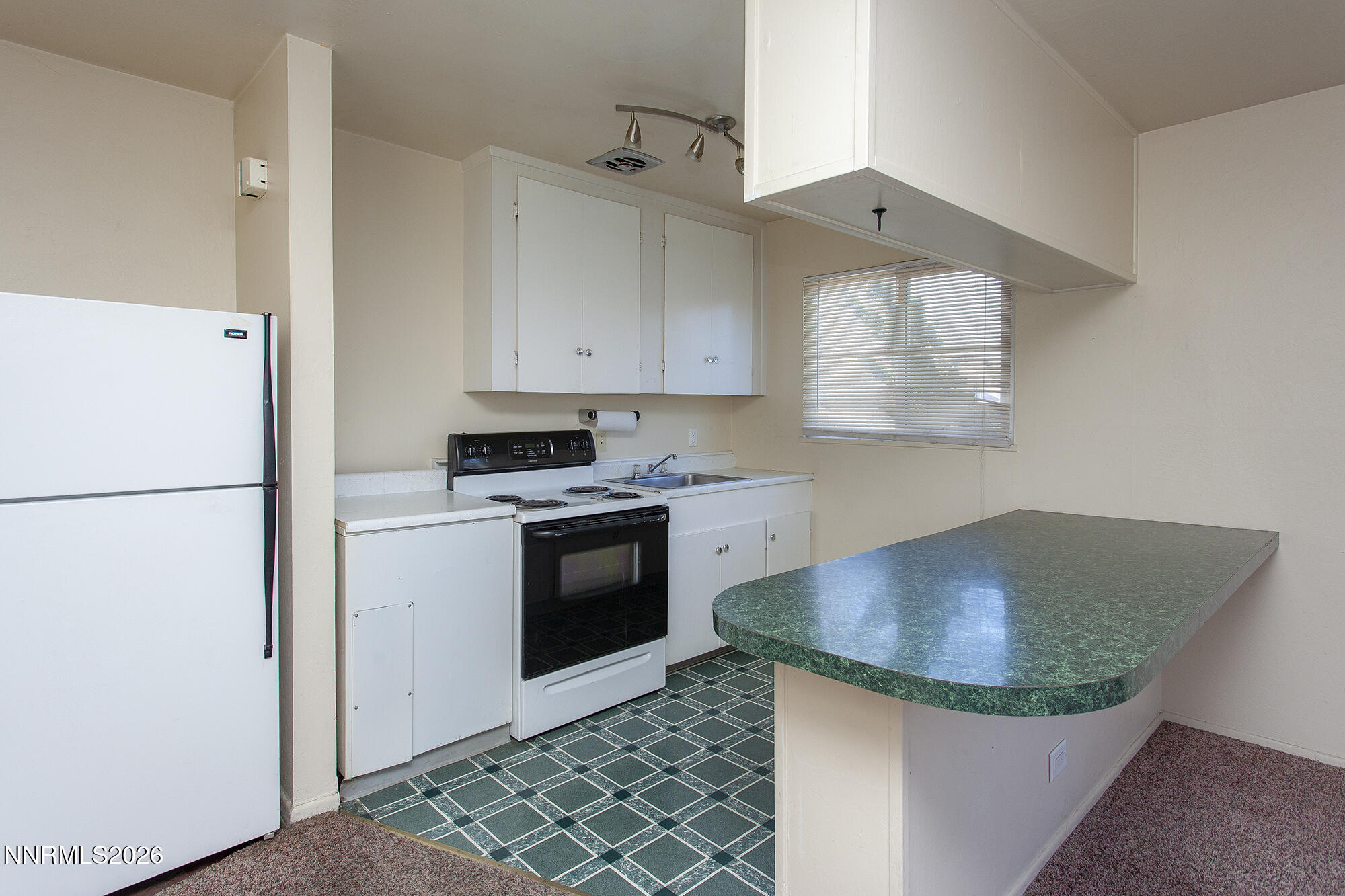 1060 Wilson Avenue Reno, NV 89502 - Photo 6 of 17 a kitchen with granite countertop a sink stove and refrigerator