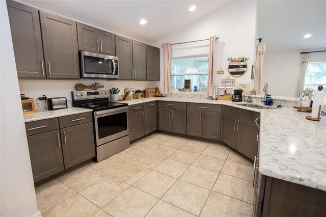 a kitchen with stainless steel appliances granite countertop a refrigerator and a stove top oven