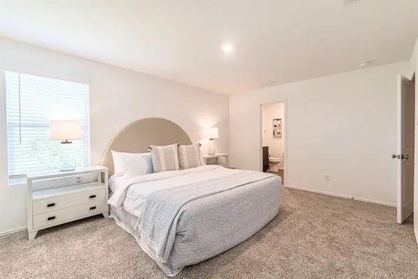 a bedroom with a large bed and a window