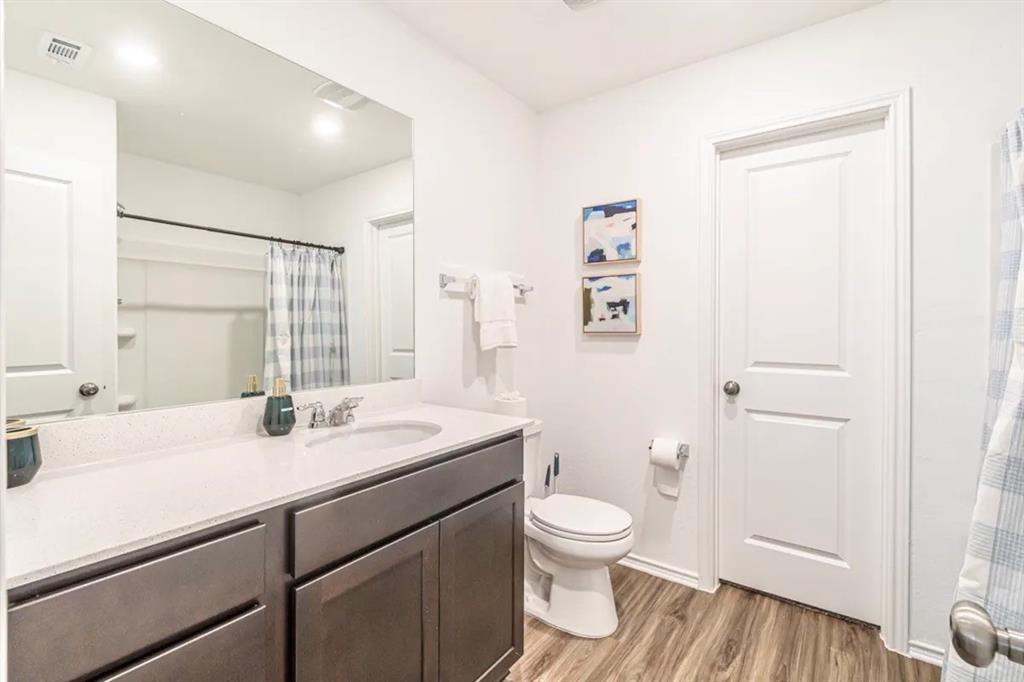 441 Gabbro Gardens Maxwell, TX 78656 - Photo 14 of 22 a bathroom with a sink a toilet and a large mirror
