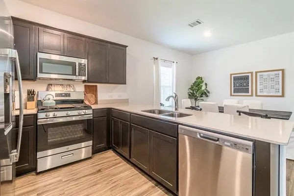 a kitchen with stainless steel appliances granite countertop a sink stove and refrigerator