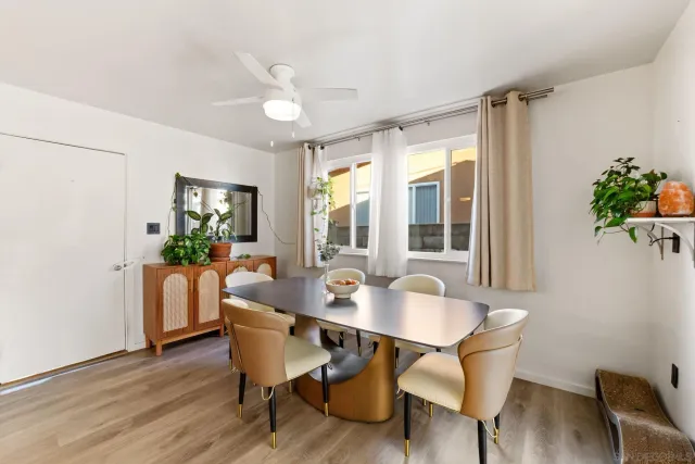 a dining room with furniture potted plants and wooden floor