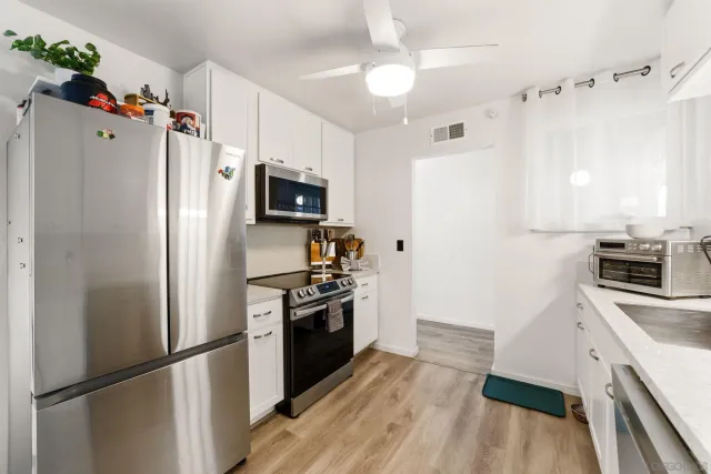 a kitchen with stainless steel appliances a refrigerator sink and microwave