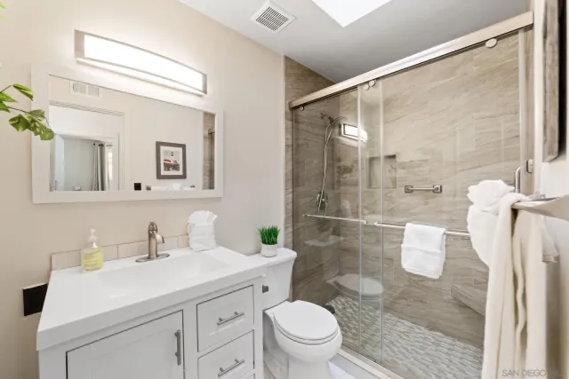 a bathroom with a sink a toilet and shower