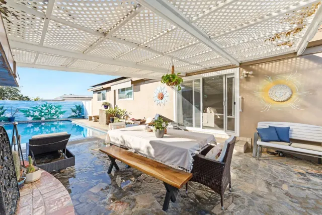 a view of a patio with a dining table and chairs with wooden floor and fence