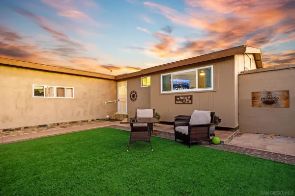 a backyard of a house with table and chairs