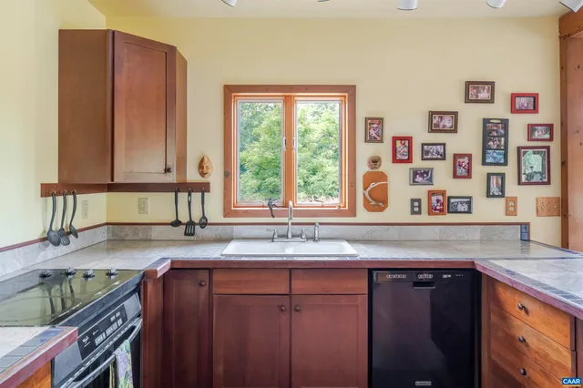 a kitchen with stainless steel appliances granite countertop a sink and a wooden cabinets