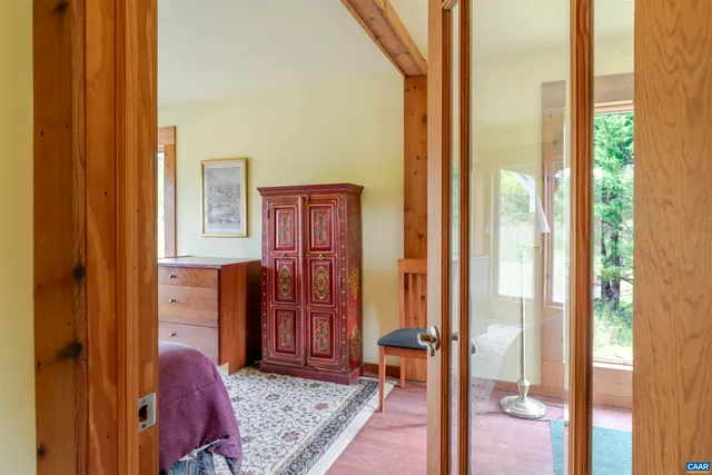 a bedroom with a bed and a dresser next to a window