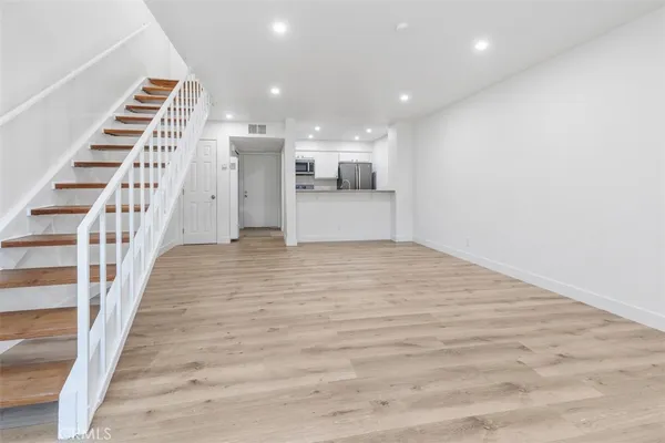 a view of entryway and hall with wooden floor