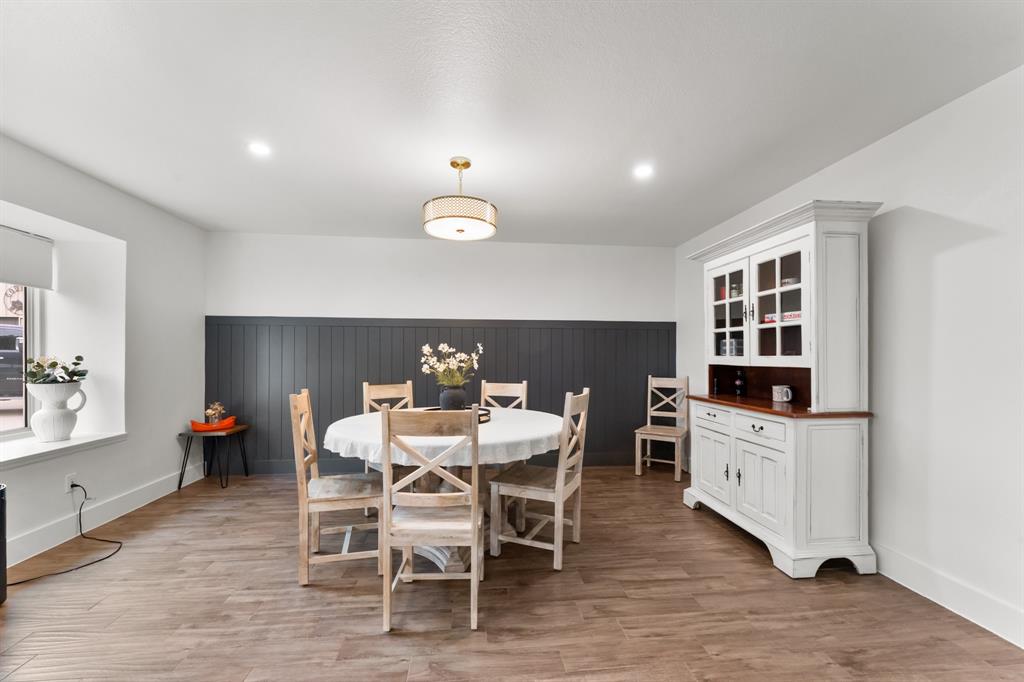 380 Farr Altom Road Seagoville, TX 75159 - Photo 8 of 30 Dining area featuring wood-finish flooring, a contemporary ceiling light fixture, recessed lighting, and a dark accent wall with paneling