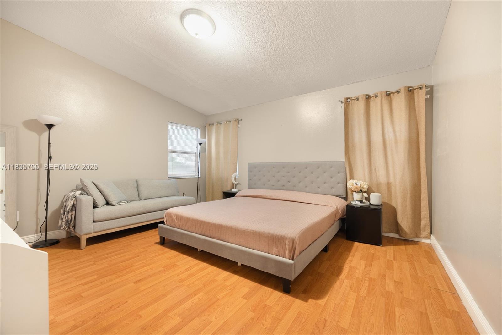 9730 Southwest 219th Street Cutler Bay, FL 33190 - Photo 14 of 25 a spacious bedroom with a bed and a couch