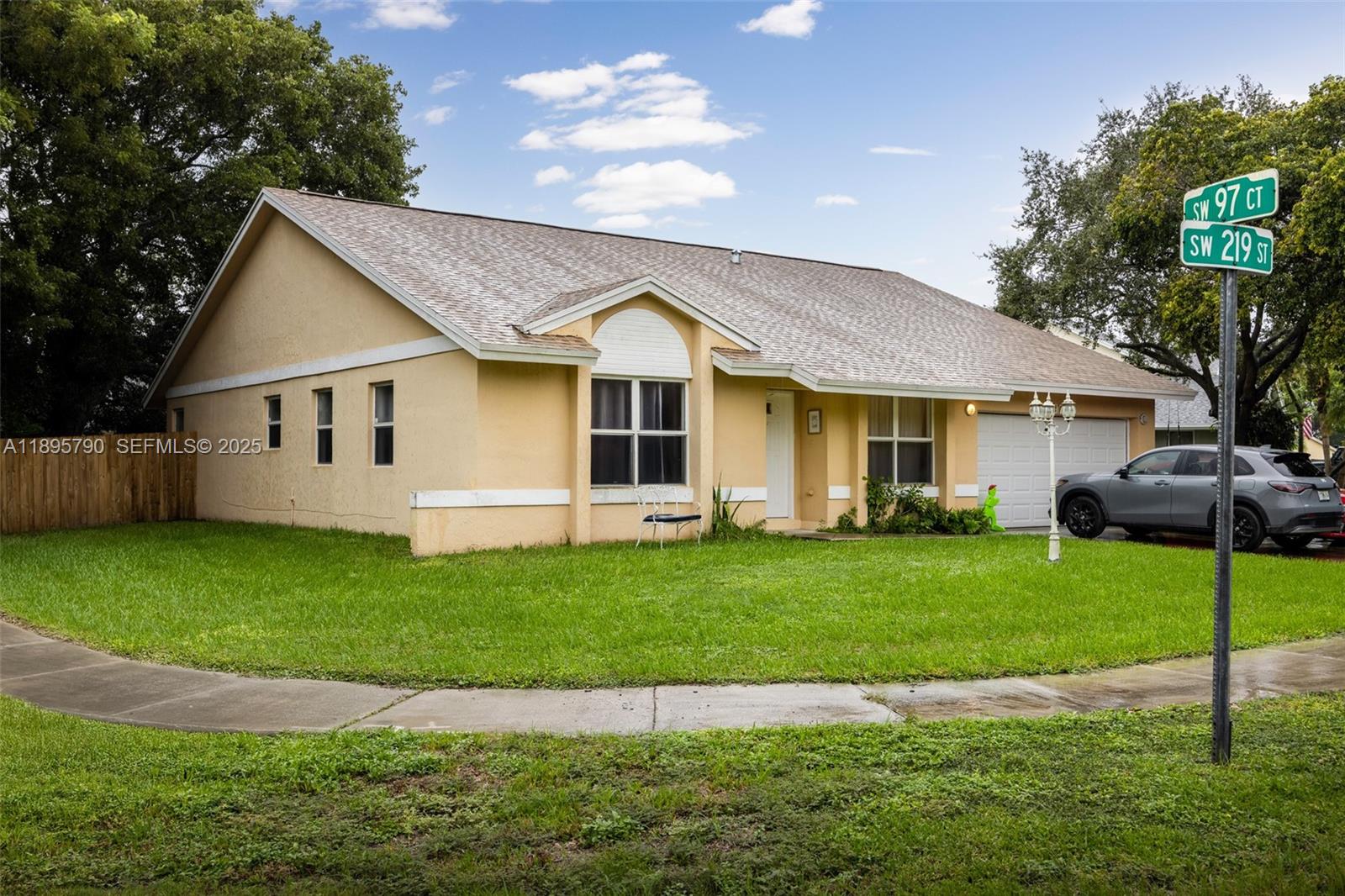 9730 Southwest 219th Street Cutler Bay, FL 33190 - Photo 2 of 25 a view of a yard in front of a house with plants and large tree