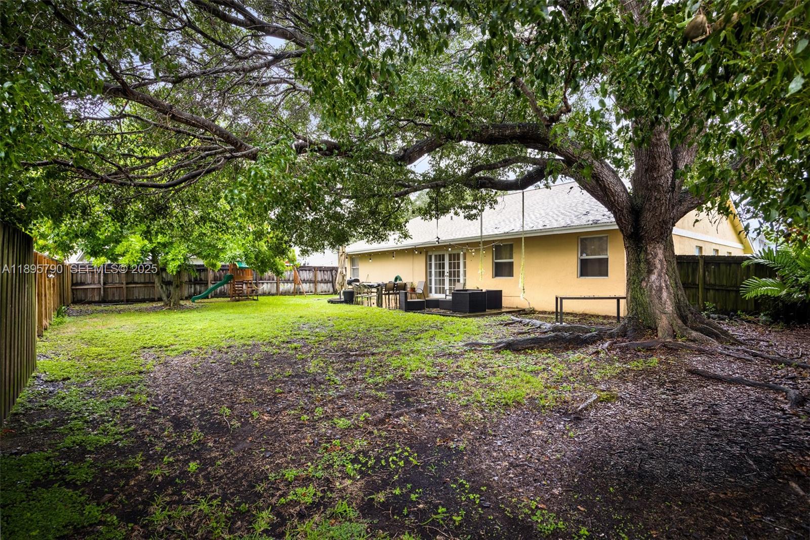 9730 Southwest 219th Street Cutler Bay, FL 33190 - Photo 24 of 25 a view of a house with backyard and trees