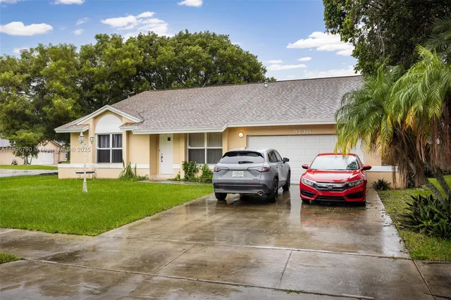 a car parked in front of a house with a garden