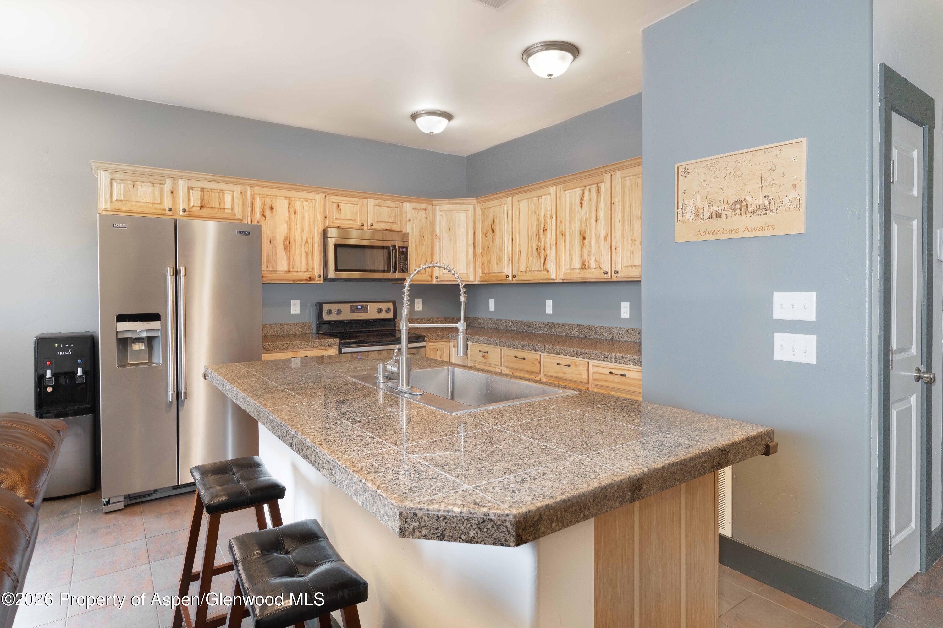 860 West 24th Street Rifle, CO 81650 - Photo 5 of 12 a kitchen with granite countertop a sink a counter top space appliances and cabinets