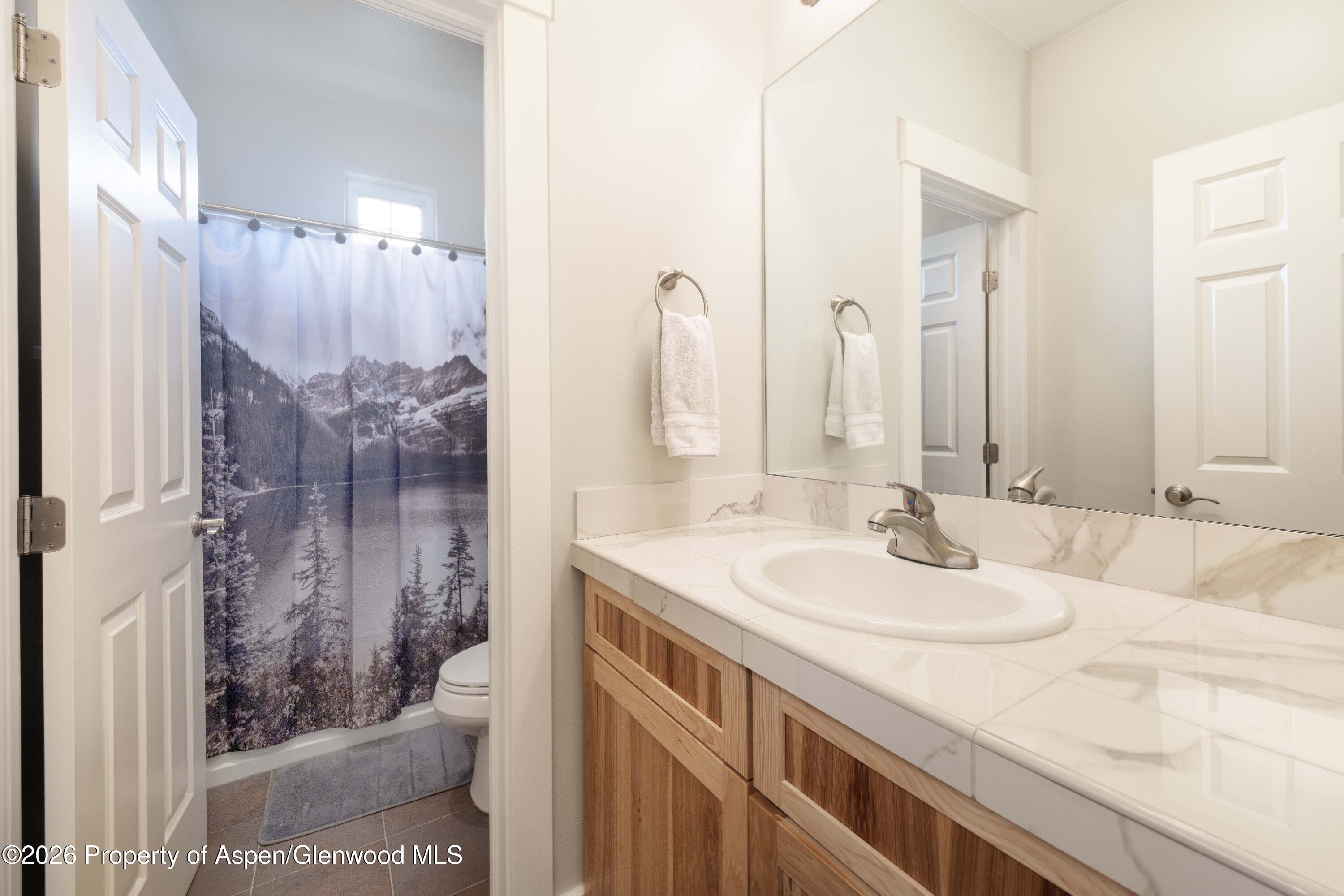 860 West 24th Street Rifle, CO 81650 - Photo 7 of 12 a bathroom with a sink and a mirror