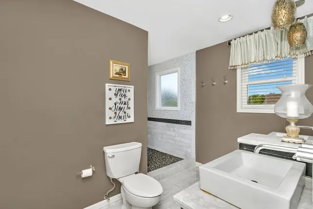 a bathroom with a toilet a sink and mirror