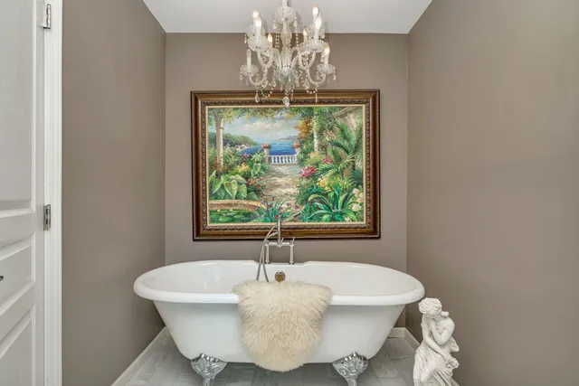 a white bath tub sitting in a bathroom next to a window
