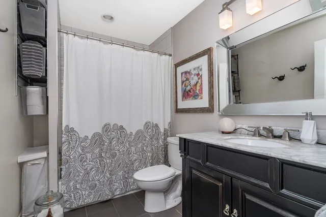 a bathroom with a granite countertop toilet sink and mirror