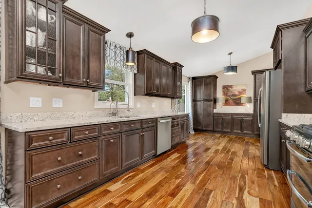 a kitchen with stainless steel appliances granite countertop a stove refrigerator and cabinets