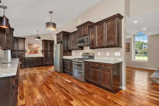 a kitchen with stainless steel appliances granite countertop a stove refrigerator and microwave