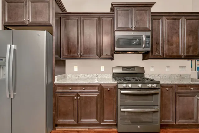 a kitchen with granite countertop a stove and a refrigerator
