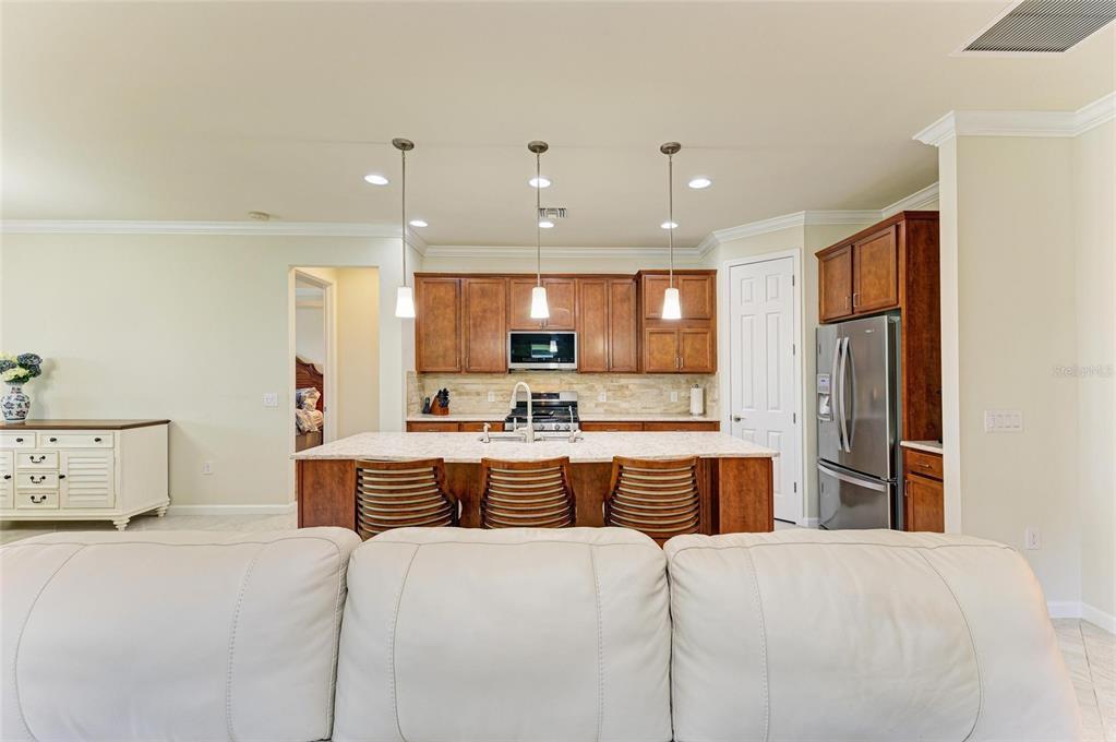 6756 Chester Trail Lakewood Ranch, FL 34202 - Photo 8 of 62 a large kitchen with kitchen island a sink a stove a refrigerator and a cabinets