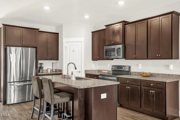 a kitchen with granite countertop a sink stove and refrigerator
