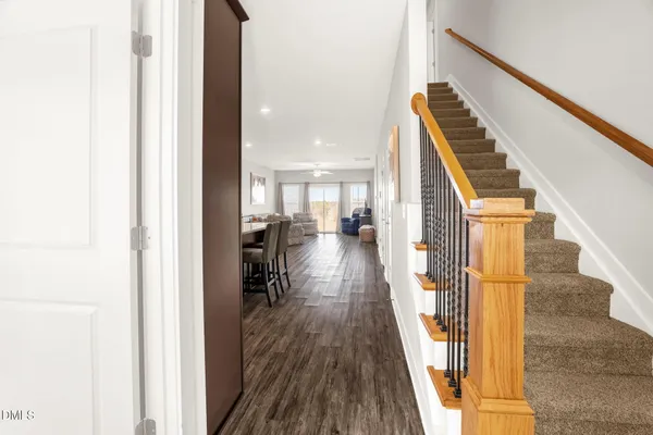 a view of a hallway with wooden floor and staircase