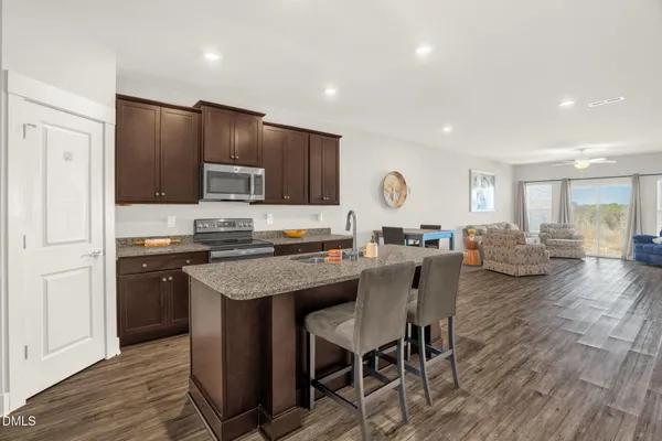 a kitchen with a table chairs refrigerator and cabinets