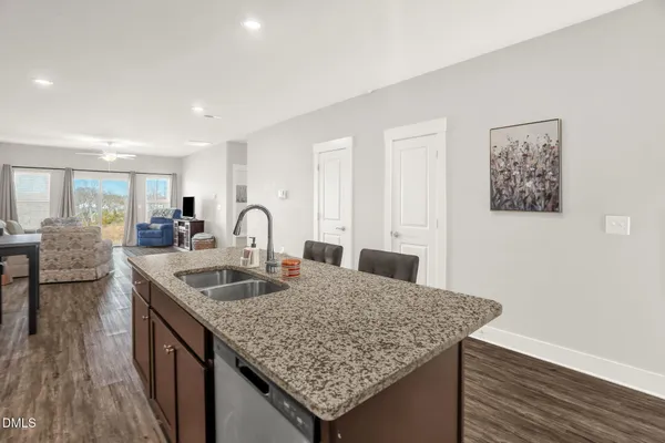 a kitchen island with granite countertop a sink and wooden floor