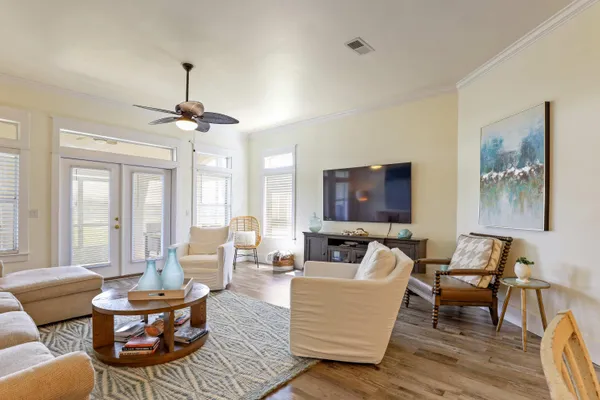 a living room with couches and a flat screen tv with kitchen view