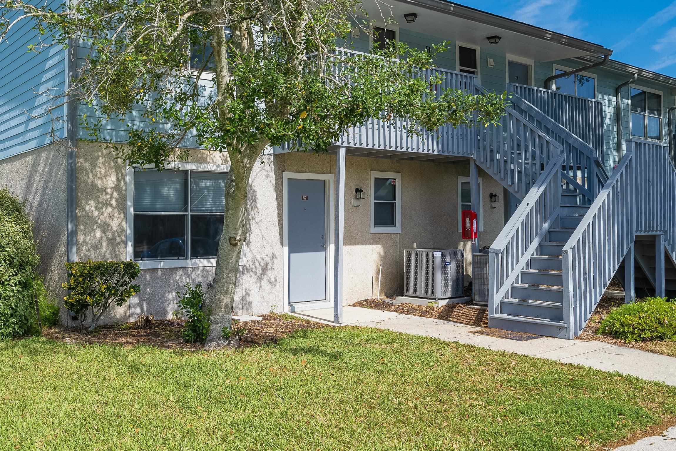 Doorway to property with a lawn and stucco siding