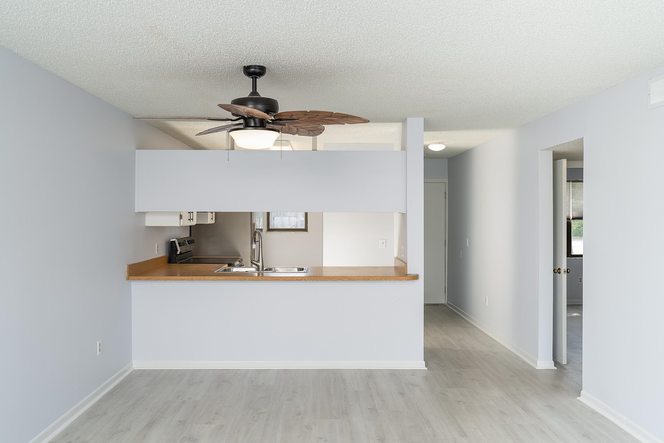 700 West Pope Road, Unit H57 St. Augustine, FL 32080 - Photo 18 of 52 Kitchen with light countertops, light wood-style flooring, stainless steel electric range oven, a ceiling fan, and white cabinetry