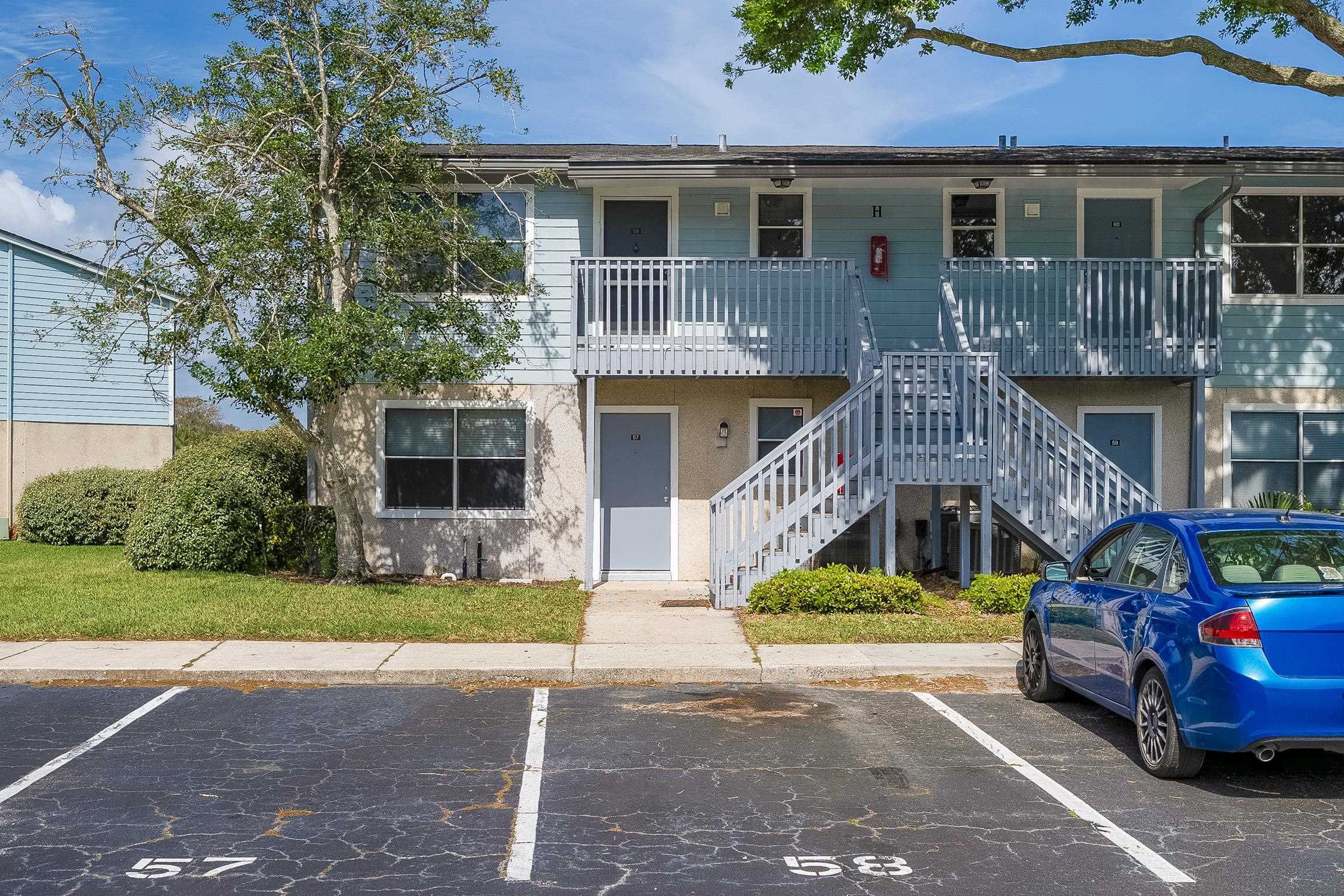 700 West Pope Road, Unit H57 St. Augustine, FL 32080 - Photo 26 of 52 View of building exterior featuring stairway and uncovered parking