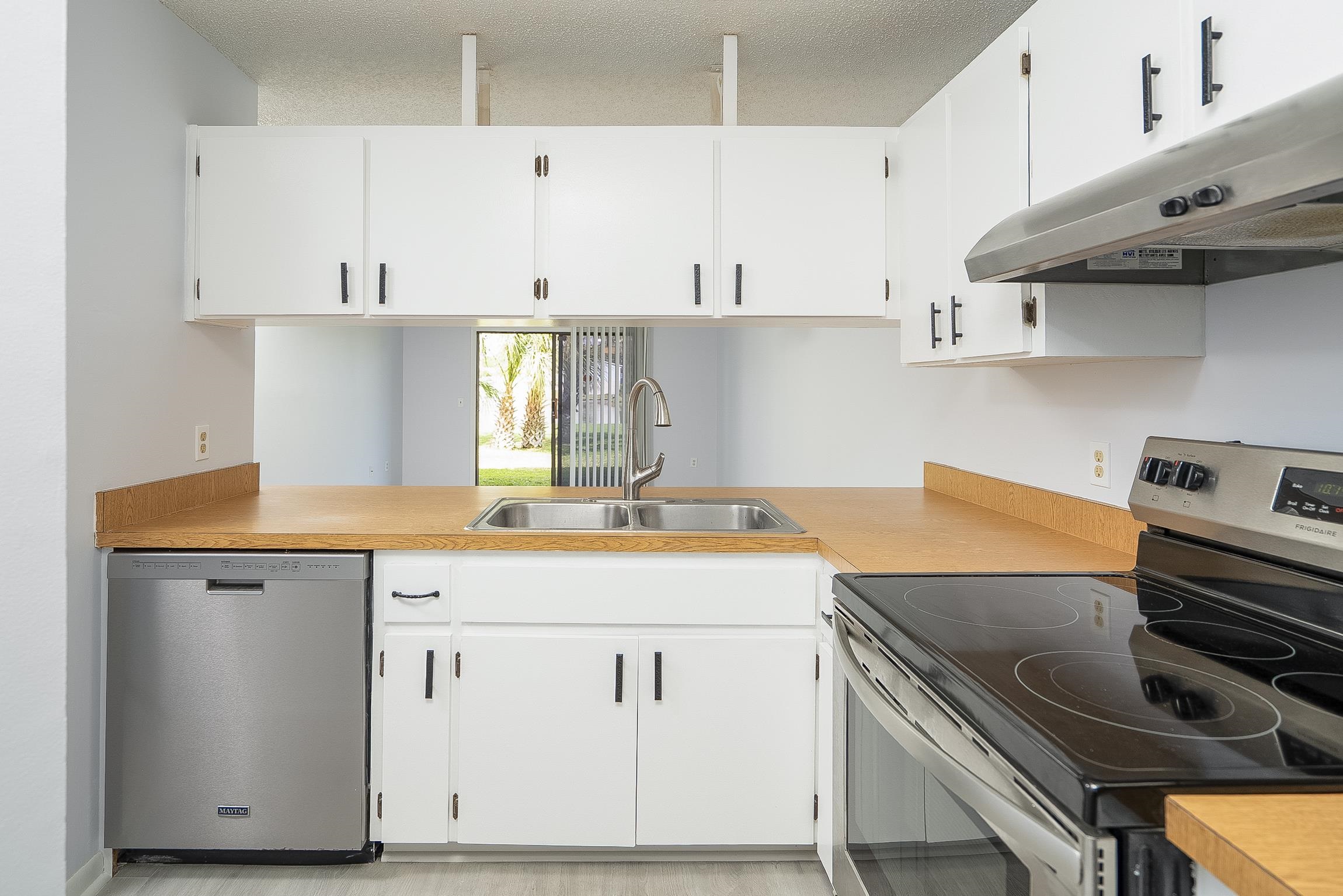 700 West Pope Road, Unit H57 St. Augustine, FL 32080 - Photo 10 of 52 Kitchen featuring stainless steel appliances, white cabinets, light countertops, and a textured ceiling