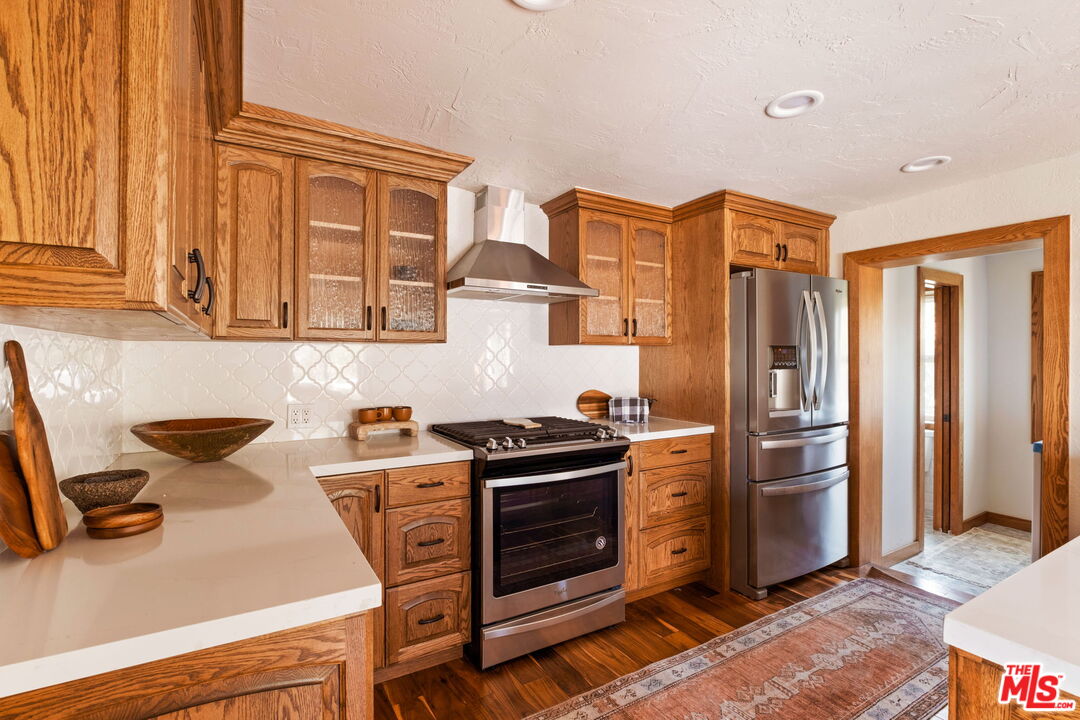 7900 Rim Canyon Road Sunland, CA 91040 - Photo 16 of 46 a kitchen with stainless steel appliances granite countertop a stove and a refrigerator