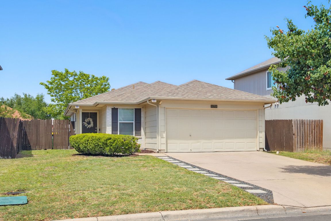 View of front of home with a garage, concrete driveway, and roof with shingles