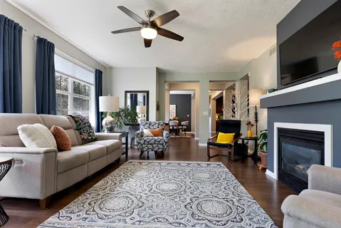 a living room with furniture a flat screen tv and a fireplace