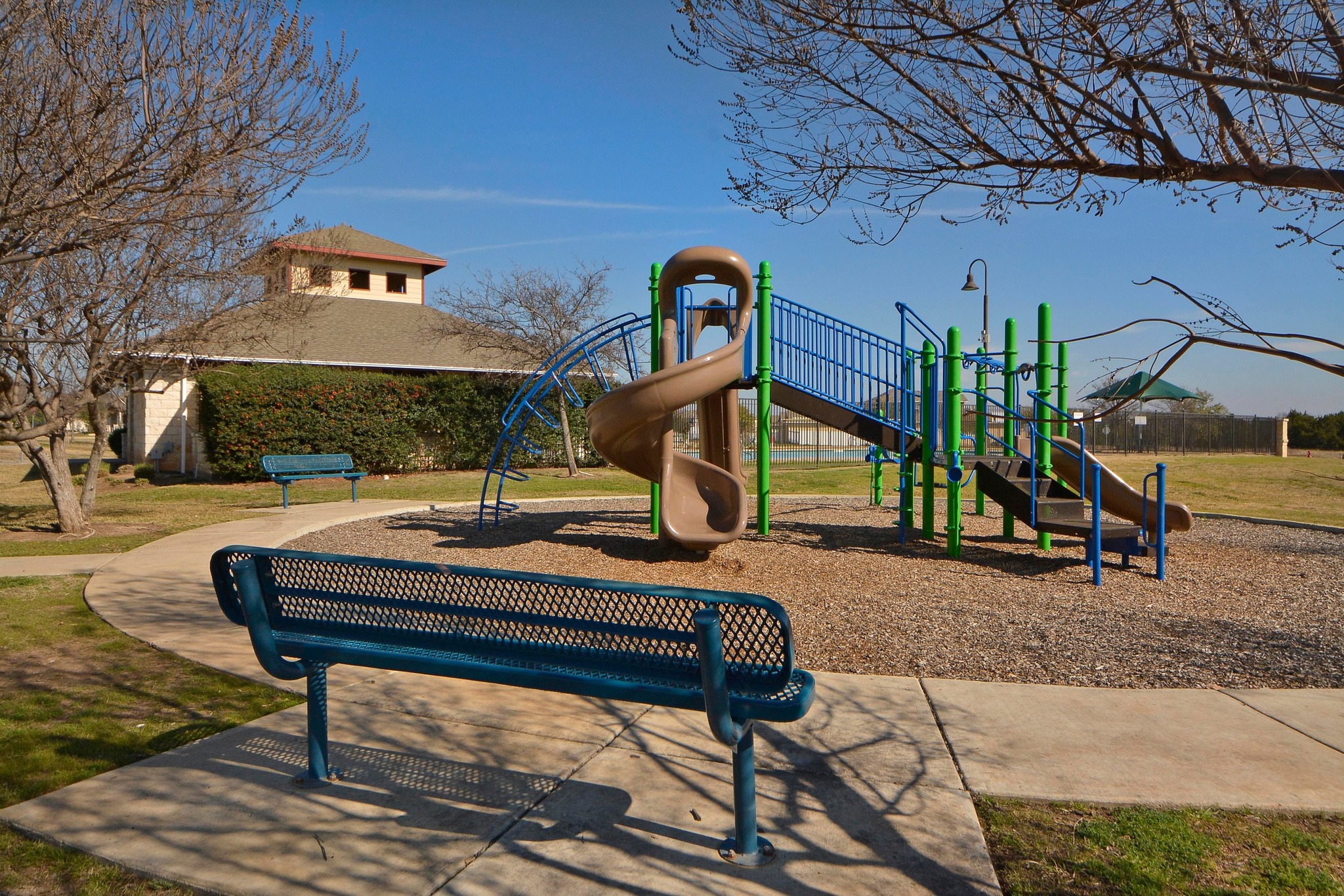 1818 Lost Maples Loop Cedar Park, TX 78613 - Photo 31 of 38 A well-maintained community playground awaits, featuring vibrant equipment set against a clear blue sky.