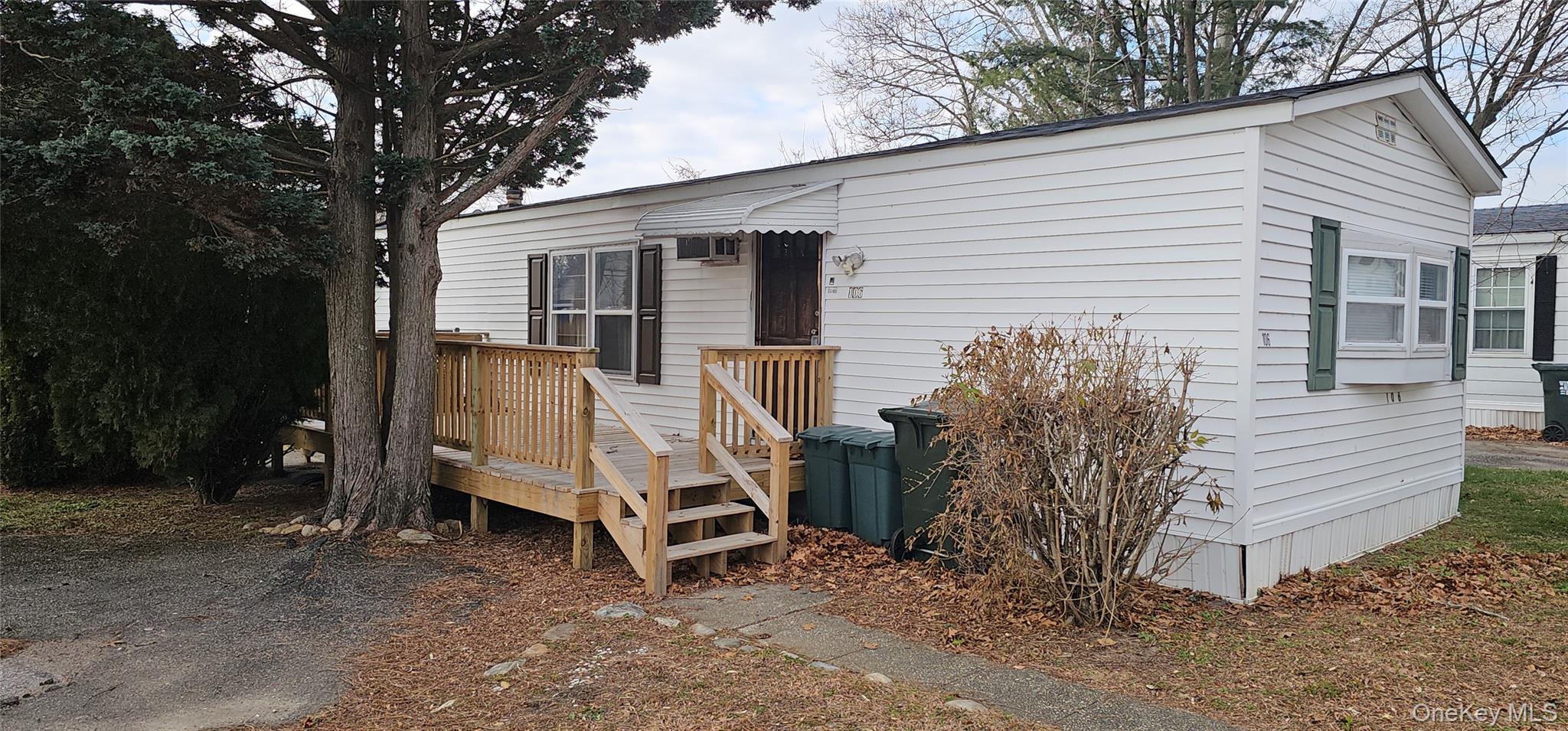 1964-106 River Road, Unit 106 Calverton, NY 11933 - Photo 19 of 26 a view of a house with a yard and wooden fence