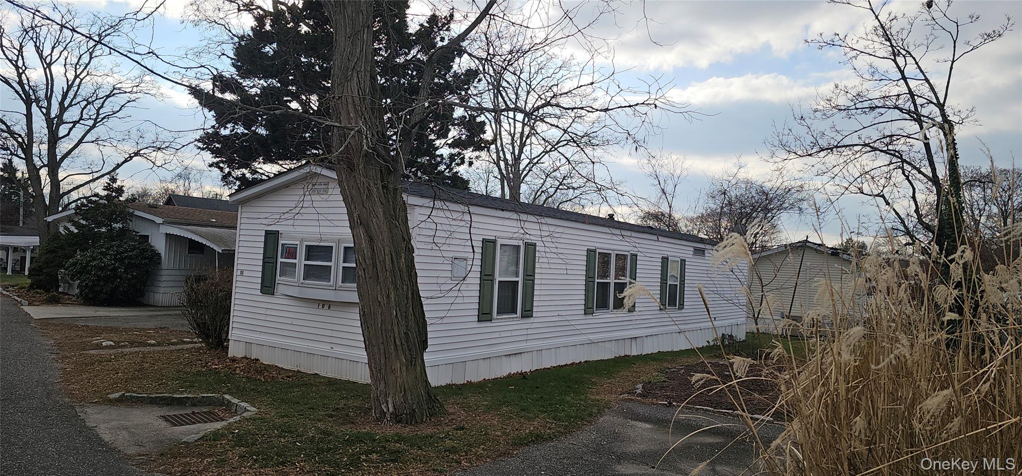 1964-106 River Road, Unit 106 Calverton, NY 11933 - Photo 20 of 26 a house with trees in front of it