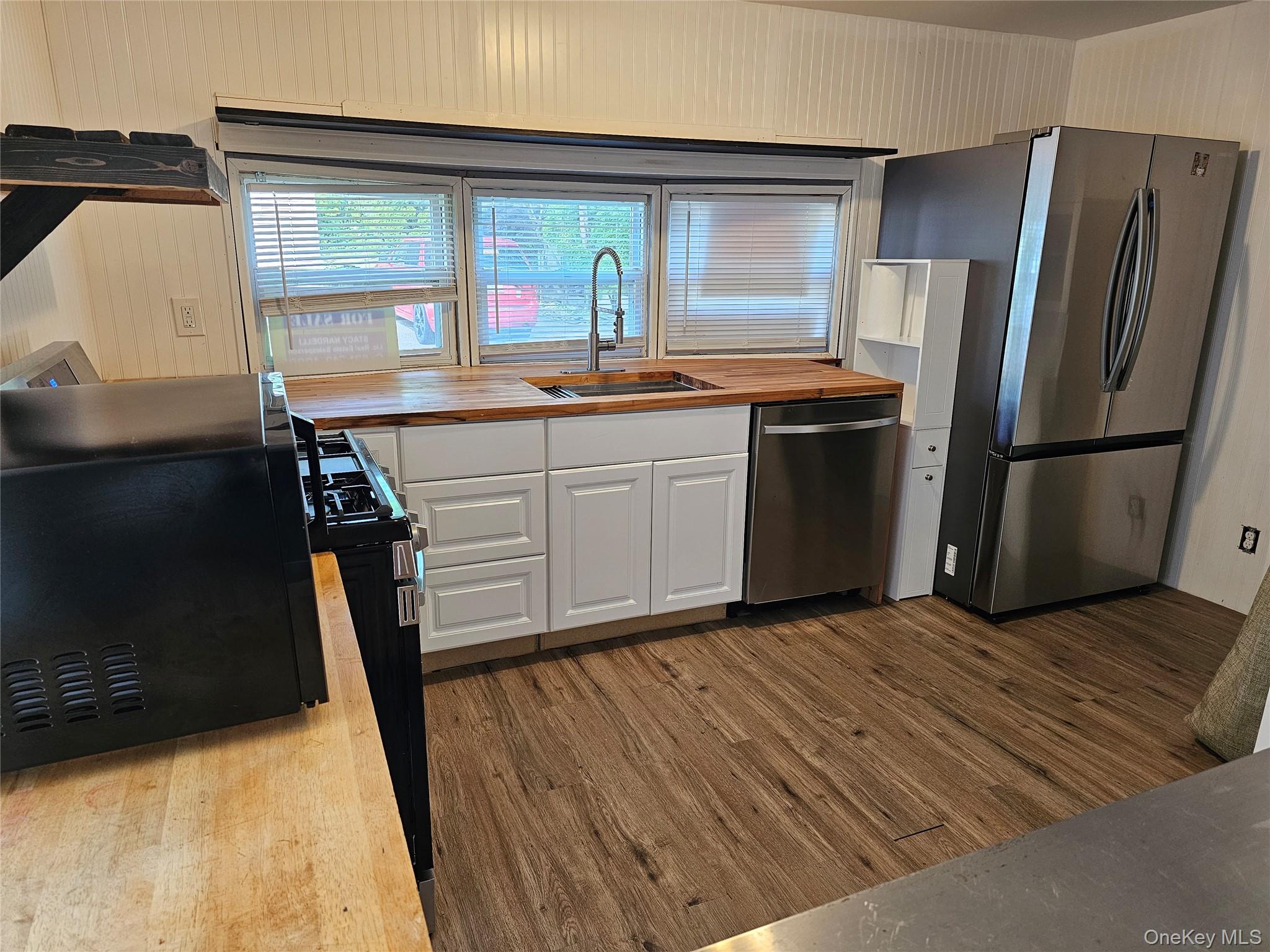 1964-106 River Road, Unit 106 Calverton, NY 11933 - Photo 4 of 26 a kitchen with stainless steel appliances granite countertop a refrigerator a sink a stove and island