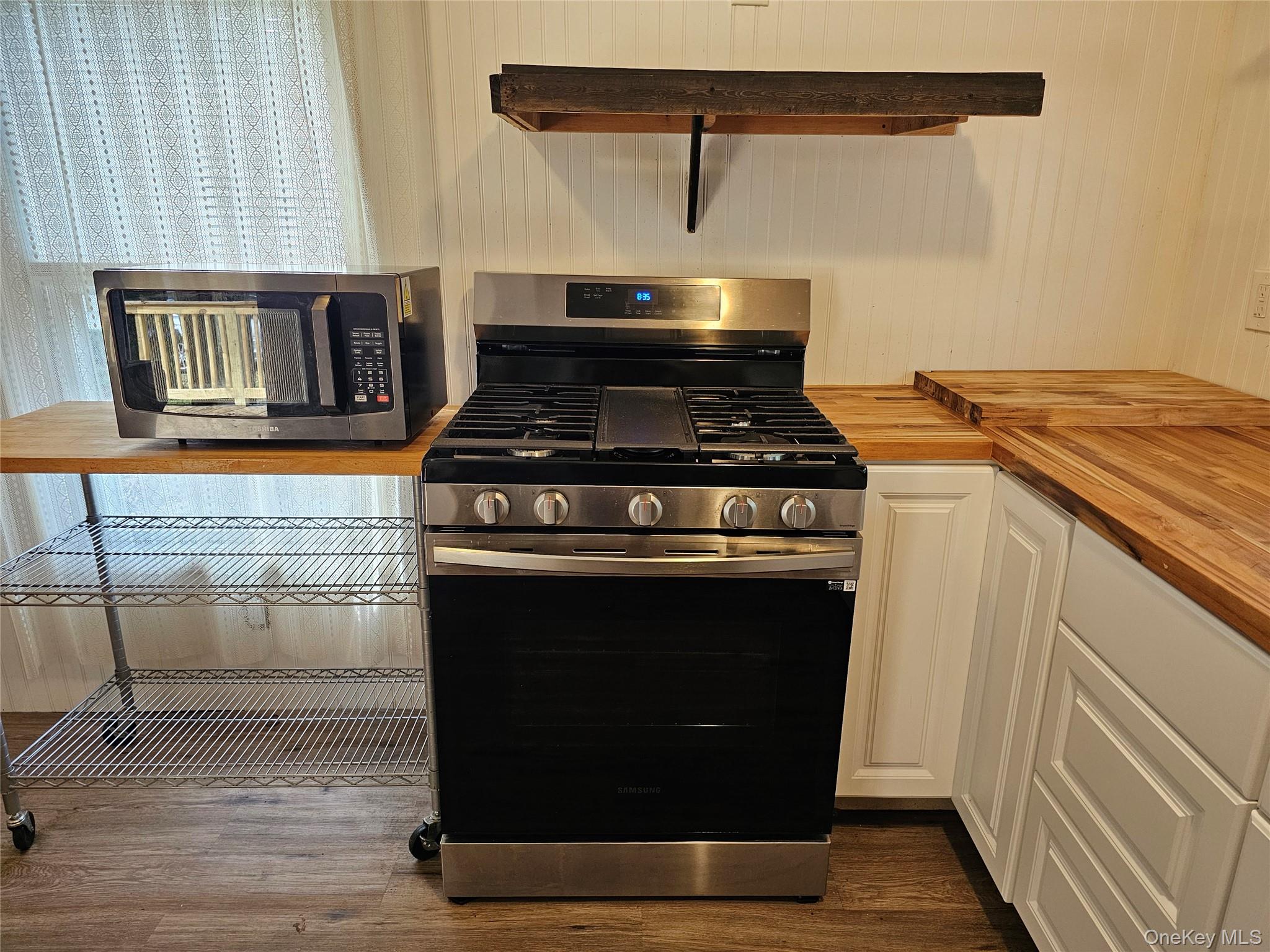 1964-106 River Road, Unit 106 Calverton, NY 11933 - Photo 7 of 26 a stove top oven sitting inside of a kitchen
